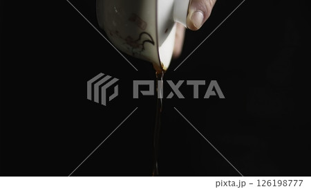 The Artistic Pouring of Tea from a Delicate Cup Captures the Essence of Serenity and Elegance. Media 126198777