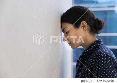 Woman employee lean her head against wall in workplace 126198850
