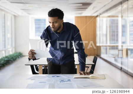 Focused African professional engaged in data analysis and decision-making 126198944