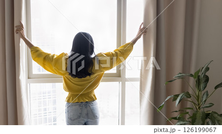 Successful confident millennial woman draw curtains on panoramic window Successful confident millennial woman draw curtains on panoramic window 126199067