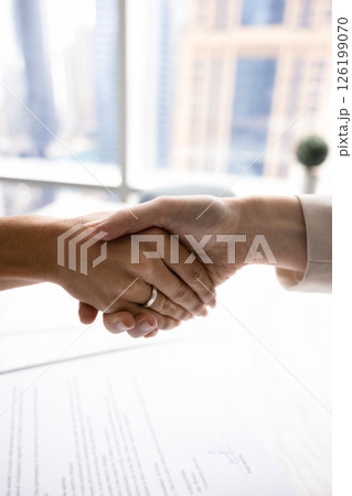 Closeup two businesspeople shaking hands in office after signing contract Closeup two businesspeople shaking hands in office after signing contract 126199070