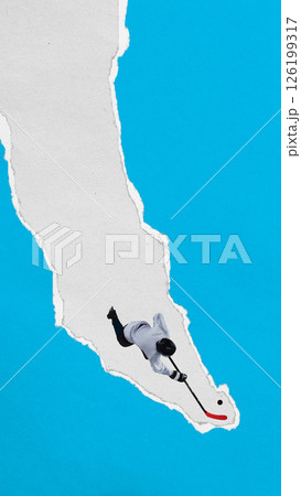 Male hockey player slides with puck through vertical torn paper stripe against blue background. Textured collage style. 126199317