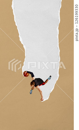 Basketball player jumps high with ball along narrow torn paper stripe on tan background. Paper texture collage. Basketball player jumps high with ball along narrow torn paper stripe on tan background. Paper texture collage. 126199330