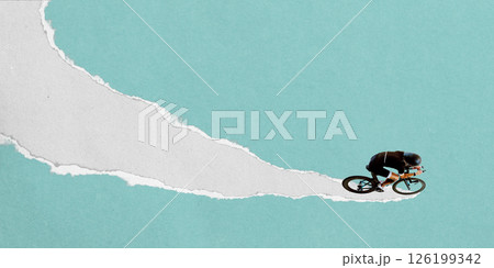 Male cyclist in aerodynamic position rides downward on curving torn paper stripe against light blue background. Textured scrap collage. 126199342