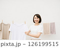室内で洗濯物を干す女性　上部余白 126199515