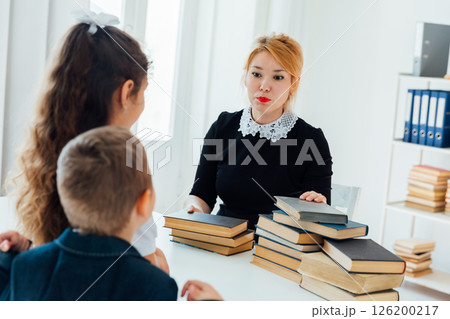 Teacher Conducting Lesson with Book for Children in School Teacher Conducting Lesson with Book for Children in School 126200217
