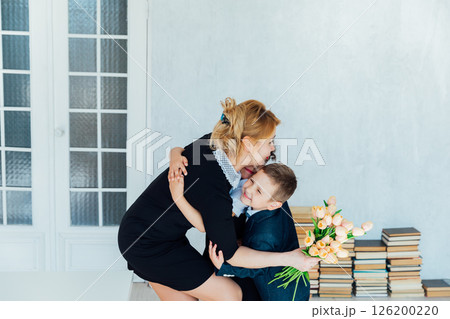 Teacher at school hugging children give flowers 126200220