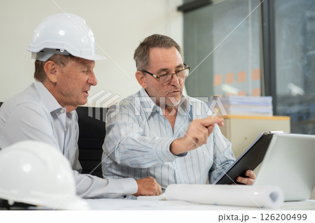Engineering Team Collaborates on Blueprint Model in Corporate Office. 126200499