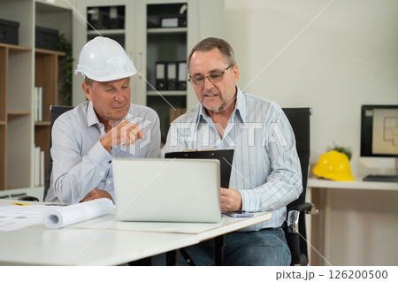 Engineering Team Collaborates on Blueprint Model in Corporate Office. 126200500