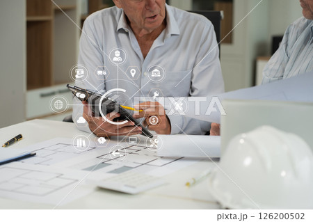 Engineering Team Collaborates on Blueprint Model in Corporate Office. 126200502