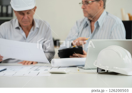Engineering Team Collaborates on Blueprint Model in Corporate Office. 126200503