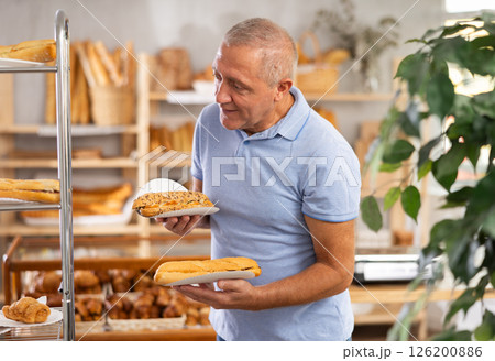Elderly man with bocadillo sandwich in bakery 126200886