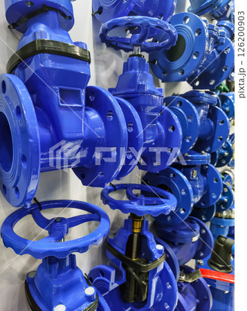 Industrial valve display showcasing various blue valves for plumbing and water systems in a local supply store Industrial valve display showcasing various blue valves for plumbing and water systems in a local supply store 126200903