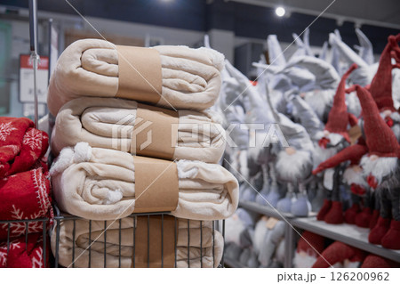 A neatly arranged stack of blankets stored in a basket within a store 126200962
