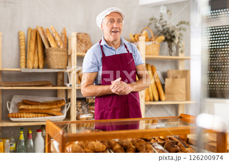 Elderly man seller posing in bakery Elderly man seller posing in bakery 126200974