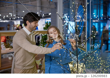 A joyful and festive family moment captured beautifully by the Christmas tree setting 126200983
