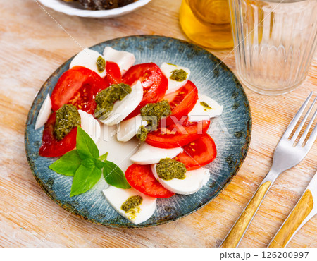 Caprese salad with tomatoes, mozzarella, basil, pesto 126200997