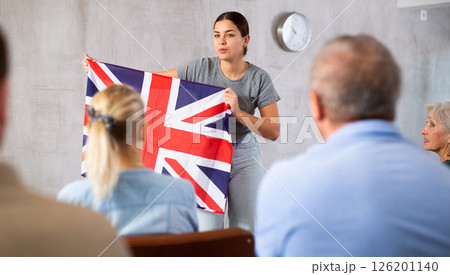 Young female teacher showing british flag to mature students 126201140
