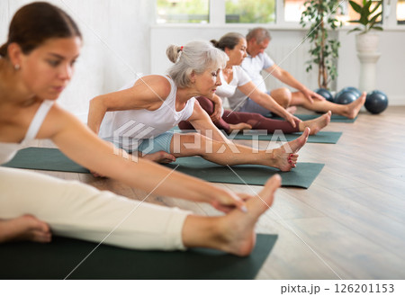 Elderly woman doing yoga on mat in studio Elderly woman doing yoga on mat in studio 126201153