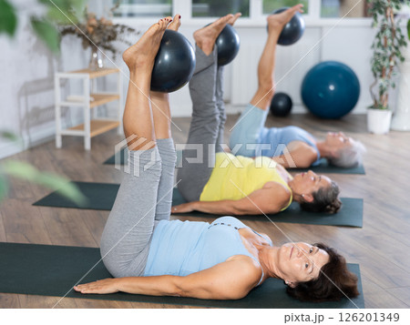Group of elderly woman doing pilates with soft ball in studio 126201349