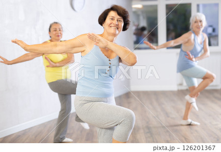 Happy mature woman practicing dance positions during workout session 126201367