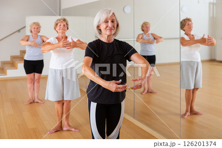 Aged woman practicing ballet dance moves in choreographic studio Aged woman practicing ballet dance moves in choreographic studio 126201374