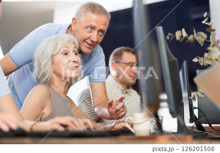 Experienced teacher of computer class assisting enthusiastic woman 126201508