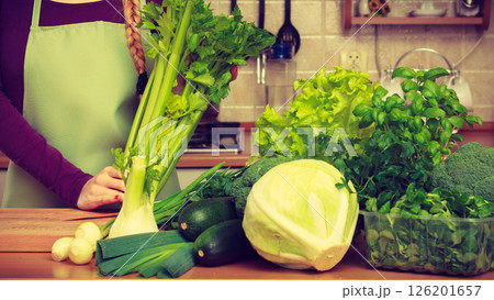 Woman in kitchen with green vegetables 126201657