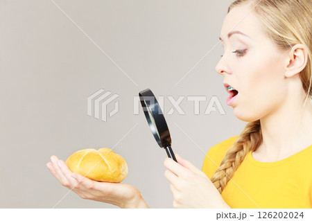 Shocked woman magnifying bun bread roll 126202024