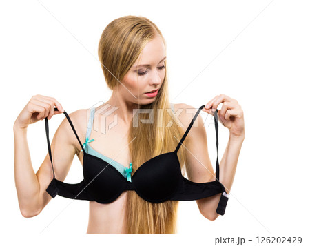 Woman trying on black pushup bra 126202429