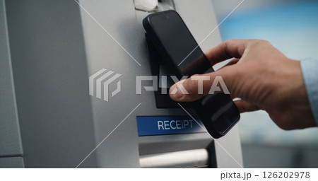 ATM Machine in Airport Terminal: Close Up of Person Putting Smartphone to NFC Reader ATM Machine in Airport Terminal: Close Up of Person Putting Smartphone to NFC Reader 126202978