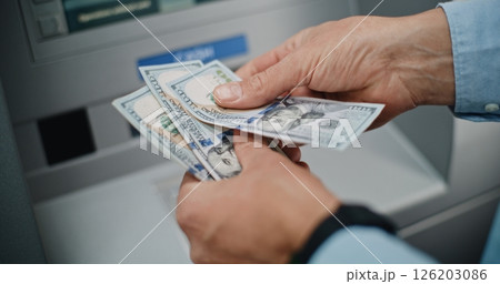 Close Up of Unrecognizable Man Counting US Dollar Bills After Withdrawing Cash 126203086