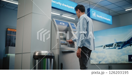 ATM Machine in Airport Terminal: Man Entering PIN Code for Money Withdrawal Operation, Taking Cash 126203195