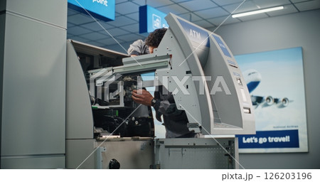 Technician Servicing ATM Machine in Modern Airport Terminal 126203196