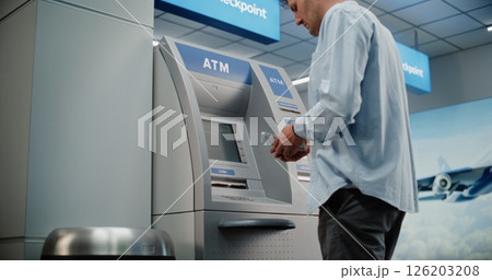 Airport Terminal: Man Pressing Buttons on ATM Keypad, Entering PIN Code, Withdrawing Cash, Taking Money 126203208