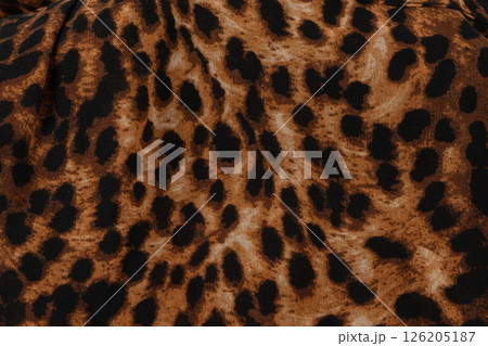 Background made of fabric with a leopard pattern. The cloth is brown with black animal spots. 126205187