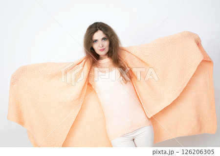Young woman wrapped in peach blanket with confidence 126206305