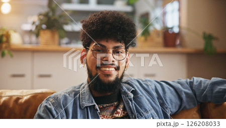 Student, glasses and portrait of man on sofa in living room for smile, gen z youth and relaxing. Happiness, pride and scholarship opportunity with person in lounge of home for calm, chill and future 126208033