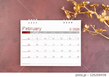 Desk calendar for February 2026 year with gold cherry blossoms branch. 126208436