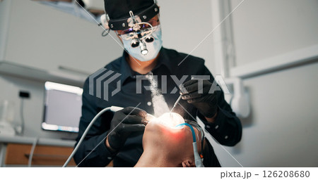 Light, medical procedure and patient with dentist in office for checkup or mouth operation. Dental appointment, healthcare or oral exam with medicine professional and woman at clinic for dentistry Light, medical procedure and patient with dentist in office for checkup or mouth operation. Dental appointment, healthcare or oral exam with medicine professional and woman at clinic for dentistry 126208680