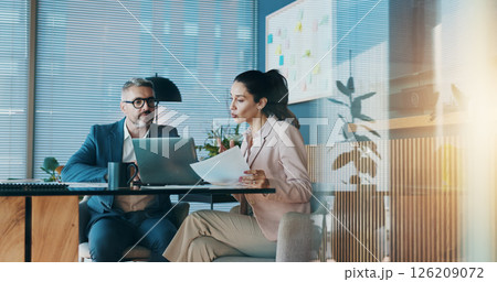 Paperwork, laptop and business people in office with meeting for company investment deal. Computer, documents and finance manager with investor client for discussion with dividend report in workplace 126209072
