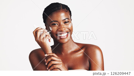 Portrait, skincare and woman with cream, studio and moisturizing of face with lotion, hydration and smile. White background, happy and black person with cosmetics for treatment, glow and smooth skin 126209447