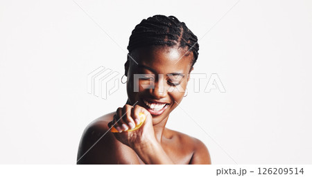 Skincare, happy and black woman with fruit in studio for wellness, organic cosmetics or vitamin c, Dermatology, spa and person squeeze lemon for natural beauty, health or benefits on white background 126209514