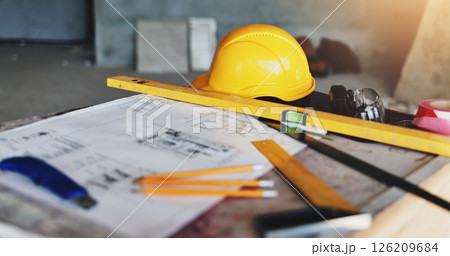 Architecture, blueprint and drawing tools with hard hat for industrial renovation, building design and planning. Safety equipment, scale and floor plan at construction site for project development 126209684