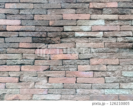 A brick wall presents rustic yet calming texture, evoking sense of enduring strength and timeless appeal with its blend of colors 126210805
