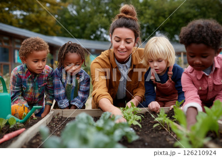 Elementary students and female teacher participating in educational gardening activity 126210924