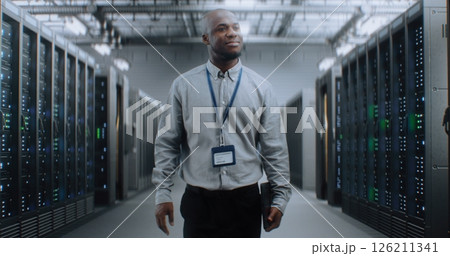 Big Data Center with Server Racks and Internet Servers: Specialist Walking In Warehouse Big Data Center with Server Racks and Internet Servers: Specialist Walking In Warehouse 126211341