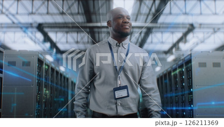 Administrator with Digital Tablet Walking in Futuristic Big Data Center with VFX, Looking at Camera 126211369