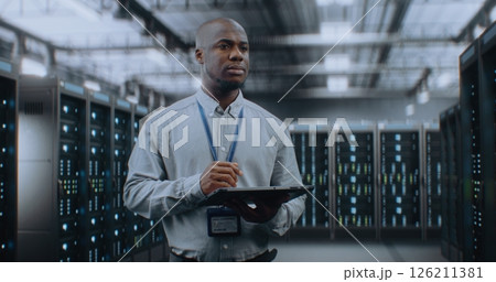 Big Data Center with Server Racks: Specialist Using Tablet Computer, Activating Servers 126211381