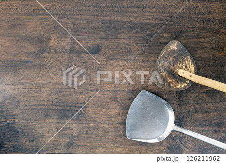 Metal and wooden spatulas rest on rustic wooden table, showcasing blend of materials and textures. contrast between shiny metal and worn wood adds character to kitchen tools Metal and wooden spatulas rest on rustic wooden table, showcasing blend of materials and textures. contrast between shiny metal and worn wood adds character to kitchen tools 126211962